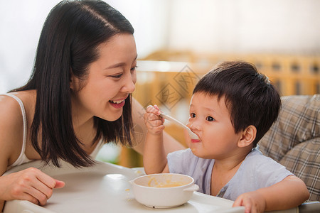 居家年轻妈妈喂宝宝吃饭婴儿食品高清图片素材