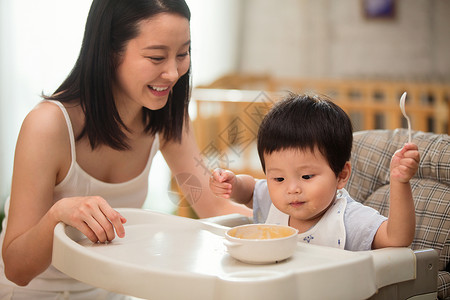 坐椅子上男孩居家年轻妈妈喂宝宝吃饭背景