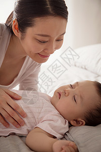 年轻妈妈陪宝宝睡觉保护高清图片素材