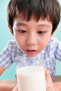 玻璃杯儿童纯洁小男孩看着一杯牛奶活力高清图片素材
