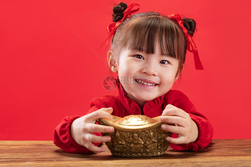 可爱的小女孩拿着金元宝图片