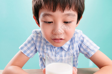儿童无忧无虑微笑小男孩看着一杯牛奶愉悦高清图片素材