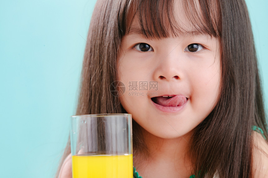 幸福天真微笑可爱的小女孩喝饮料图片