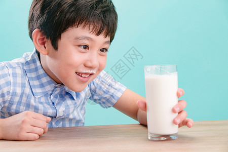 磨豆浆的孩子无忧无虑亚洲幸福小男孩看着一杯牛奶背景