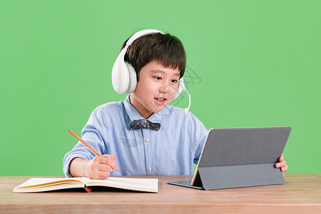 天真可爱的东亚小学生使用平板电脑在线学习背景图片