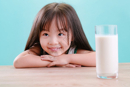 不看镜头无忧无虑成长可爱的小女孩和一杯牛奶中国人高清图片素材