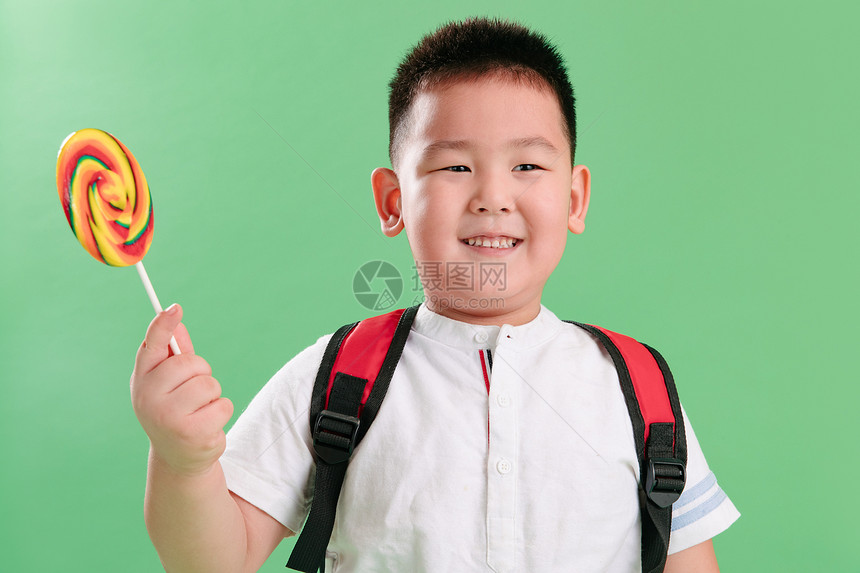 不看镜头幸福清新可爱的小男孩拿着棒棒糖图片