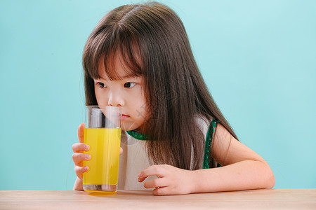 纯洁人营养可爱的小女孩喝饮料蓝色背景高清图片素材