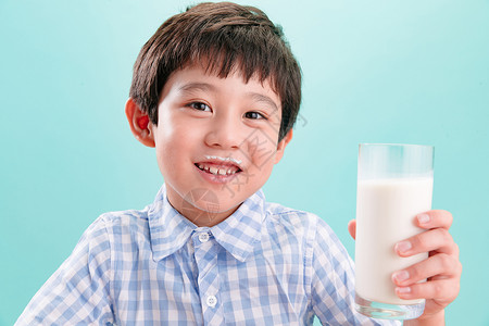 蓝色背景亚洲休闲装小男孩和一杯牛奶好奇心高清图片素材
