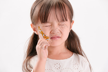 小女孩表情包影棚拍摄伤心闭上眼睛脸上受伤的小女孩背景