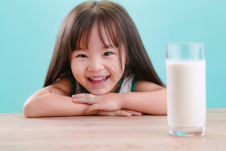 儿童好奇心影棚拍摄可爱的小女孩和一杯牛奶健康高清图片素材