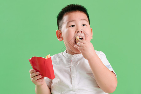 影棚拍摄肥胖可爱的小男孩吃薯条背景