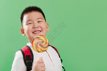 可爱的小男孩拿着棒棒糖高清图片