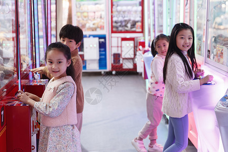 游乐园男孩女孩在游戏厅玩耍图片