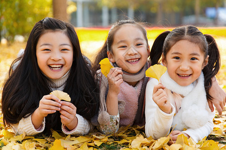 秋天玩耍的小孩欢乐的小女孩在户外玩耍背景