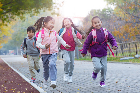 欢乐的小学生在户外奔跑玩耍高清图片素材