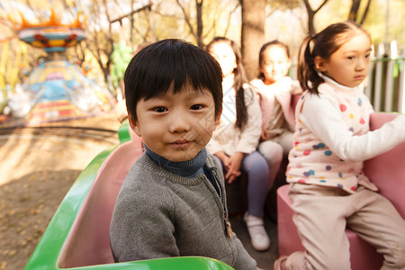 游乐园男孩女孩坐在游乐场玩耍图片