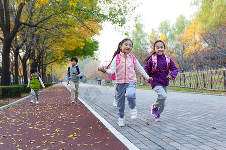 欢乐的小学生在户外奔跑嬉戏的高清图片素材