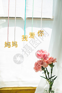 我爱汉字桌上的康乃馨花和信封贺卡背景
