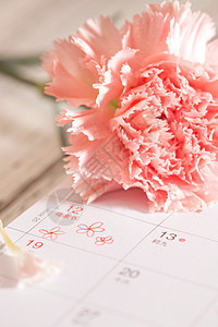 水滴装饰桌上的康乃馨花和信封贺卡背景
