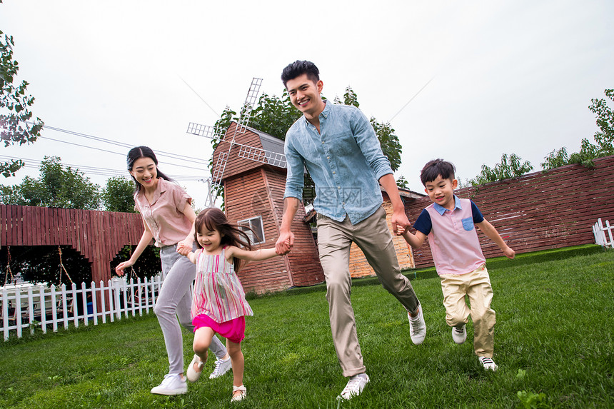 东方人放松丈夫快乐家庭在草地上奔跑图片