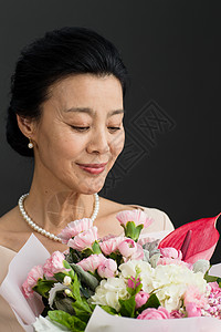 手拿一束康乃馨财富中老年女人女人手拿鲜花的优雅女士背景