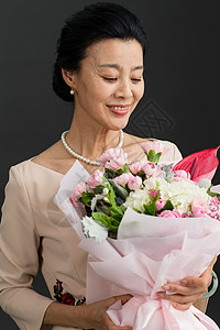 手拿一束康乃馨成年人完美幸福手拿鲜花的优雅女士背景