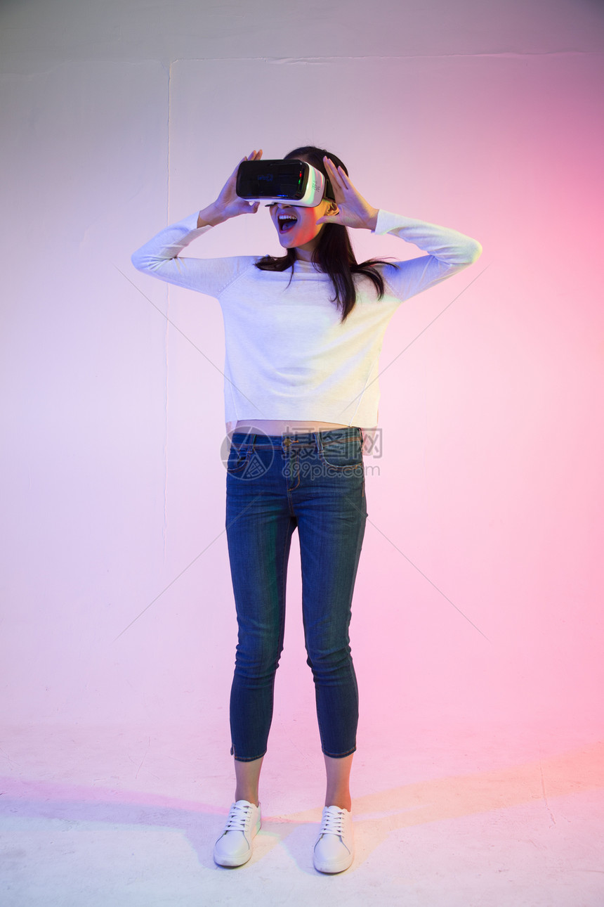 虚拟戴着VR眼镜的青年女人图片