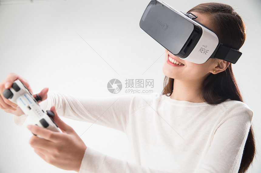 娱乐快乐遥控器戴着VR眼镜的青年女人图片