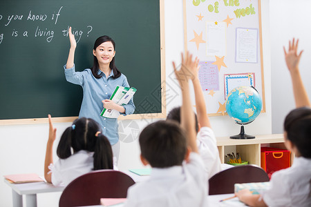 小学生在学习黑板亚洲表现积极老师和小学生们在教室里背景