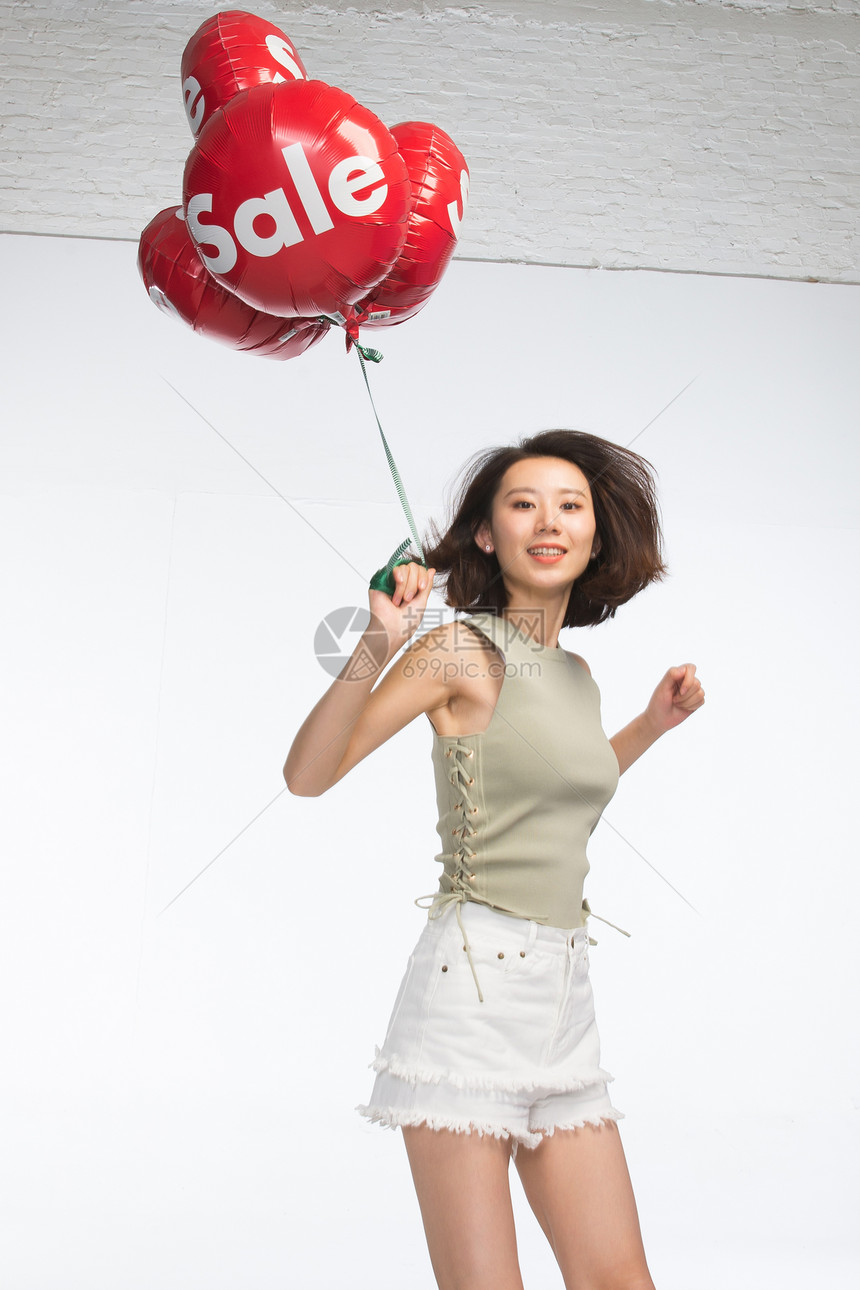 女人愉悦满意快乐的年轻女孩拿着气球图片
