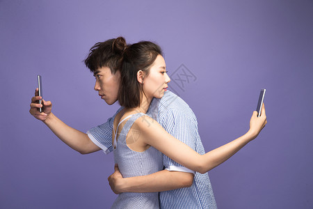 拟人化性格各自玩手机的青年情侣背景