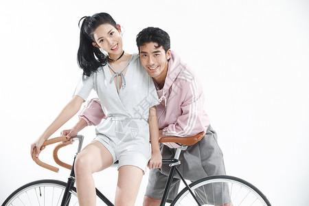 骑车玩耍的情侣女朋友时尚影棚拍摄青年情侣骑自行车背景