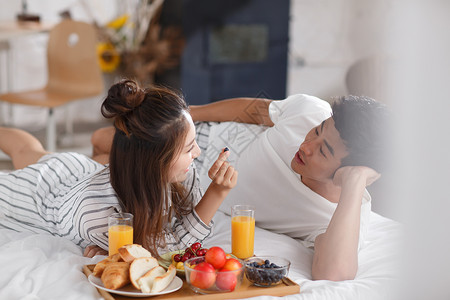 青年情侣在床上吃早餐高清图片