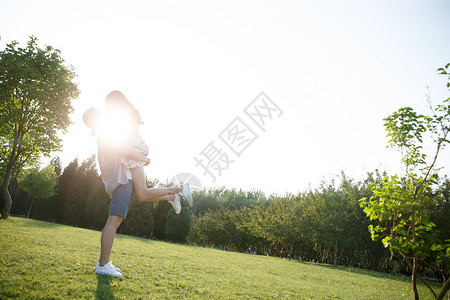 抱着太阳的女孩乐趣愉悦日光快乐情侣户外玩耍背景