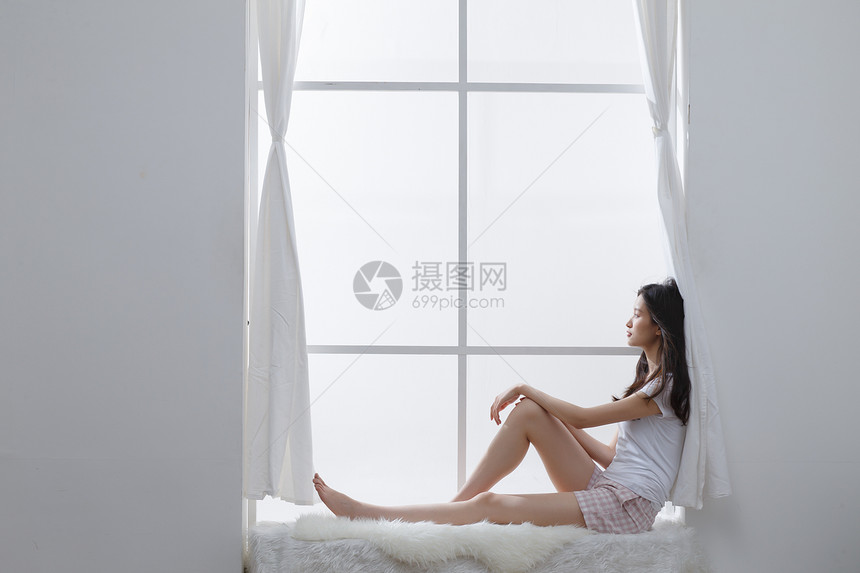 舒适乐趣青年人青年女人坐在窗户旁边图片