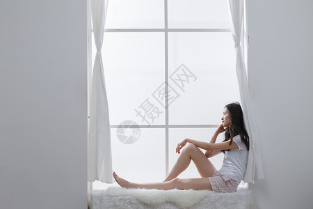 起居室独处亚洲青年女人坐在窗户旁边赤脚高清图片素材