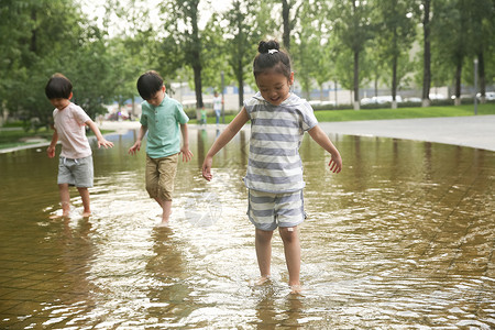 池塘戏水白昼不看镜头快乐儿童在户外蹚水玩背景