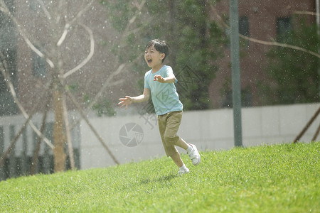 雨中奔跑的男孩喷泉社区绿色小男孩在户外玩耍背景