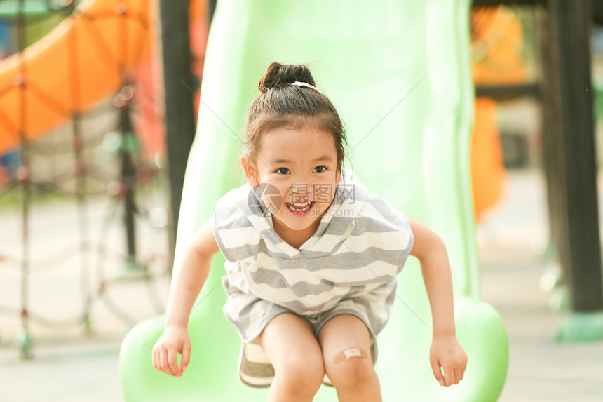 幸福东方人小女孩在户外玩滑梯图片