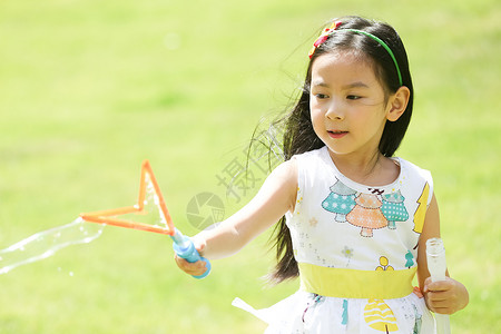 绿色与黄色泡泡彩色图片儿童东方人小女孩在户外玩耍背景