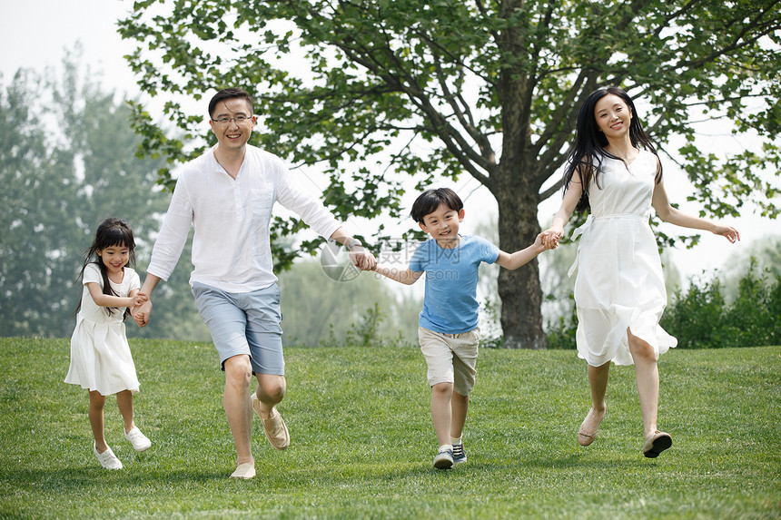 青年女人动作休闲快乐家庭在草地上奔跑图片