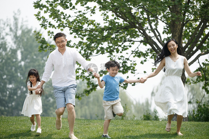 可爱的郊游30岁到34岁快乐家庭在草地上奔跑图片