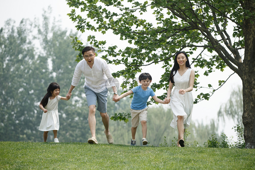 人青年伴侣相伴快乐家庭在草地上奔跑图片