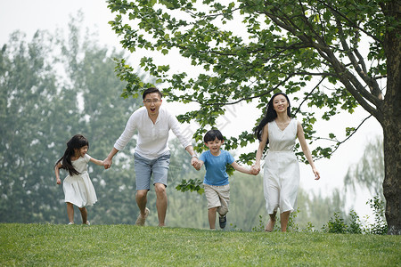 东方人四个人全身像快乐家庭在草地上奔跑图片