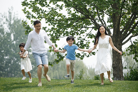 郊游快乐家庭在草地上奔跑图片