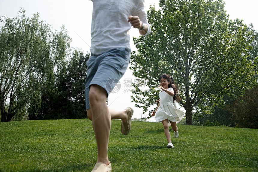 郊游快乐家庭在草地上奔跑图片