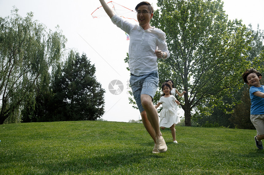 快乐家庭在草地上奔跑图片