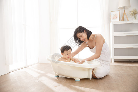 婴儿泡泡摄影保护东亚妈妈给宝宝洗澡背景