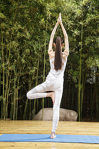 瑜伽背心园林自由青年女人练习瑜伽背景